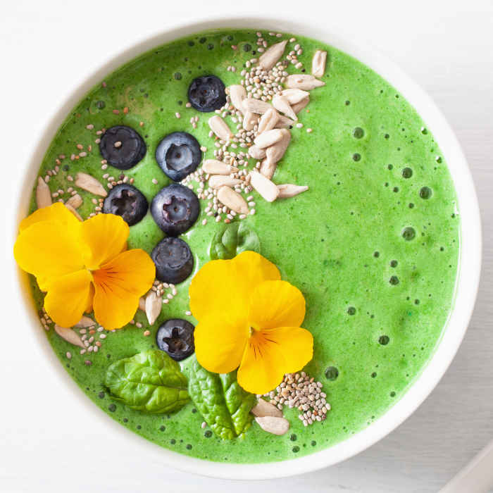 green spinach smoothie bowl with blueberry, chia seed and edible